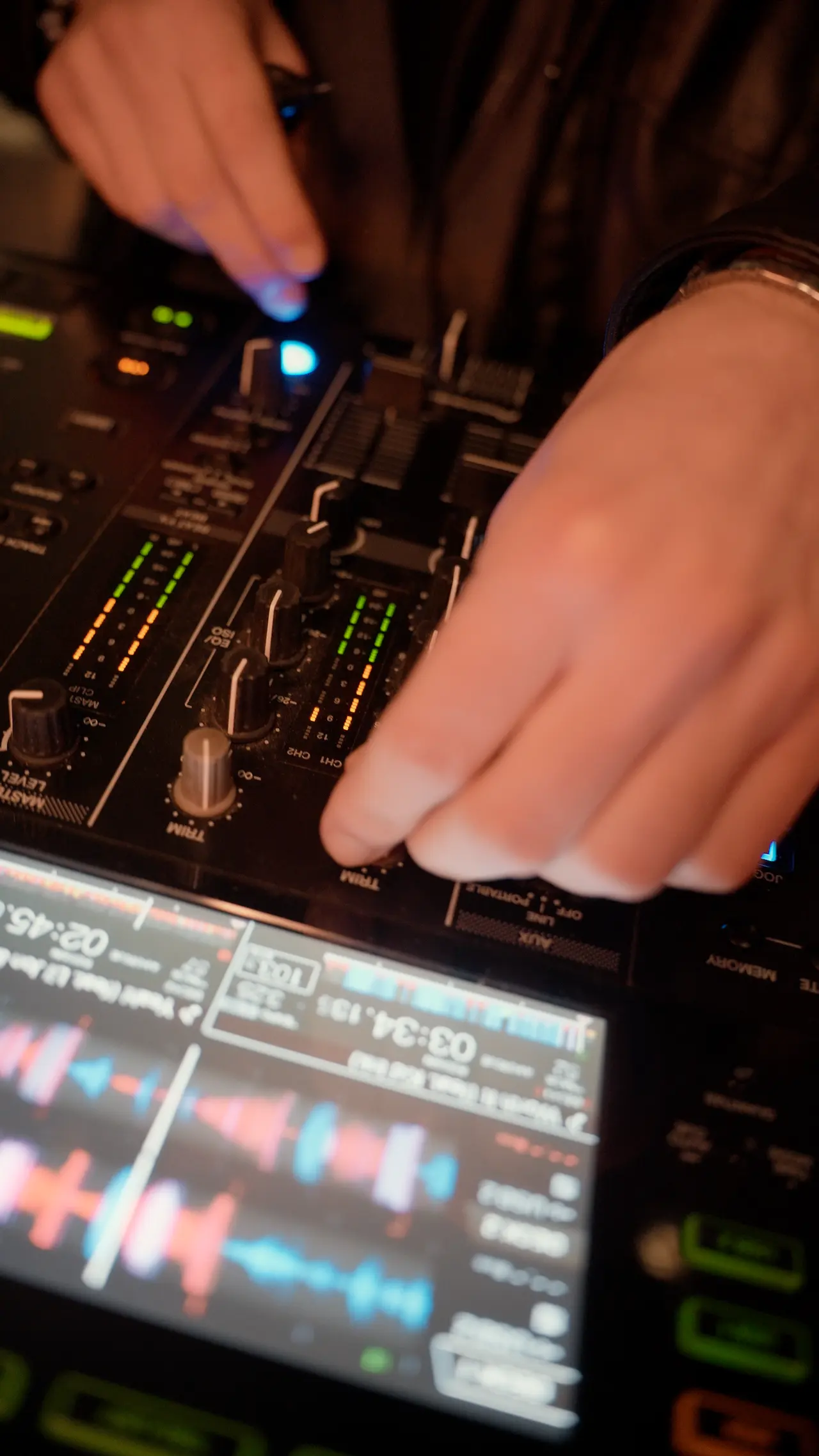 Le mani del DJ sul mixer della consolle